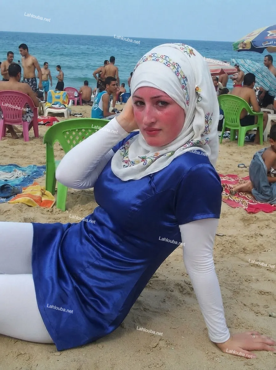 فتاة محجبة ترتدي بوركيني أزرق وأبيض على الشاطئ