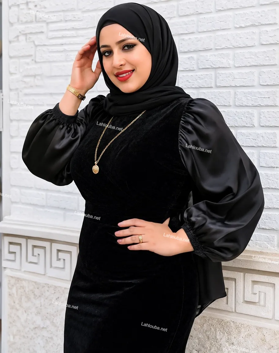 فتاة ترتدي فستان أسود مخمل بأكمام ساتان بالون مع حجاب أسود ومجوهرات ذهبية